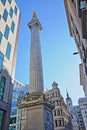 The Monument to the great fire in London surrounded by modern buildings in the financial district of the City of London with St Ma